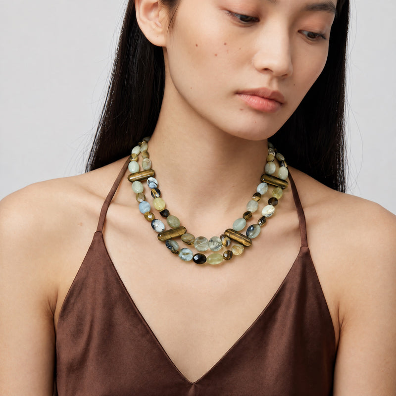 Tiger's eye, prehnite and jade two-strand necklace worn on a model in a brown satin top