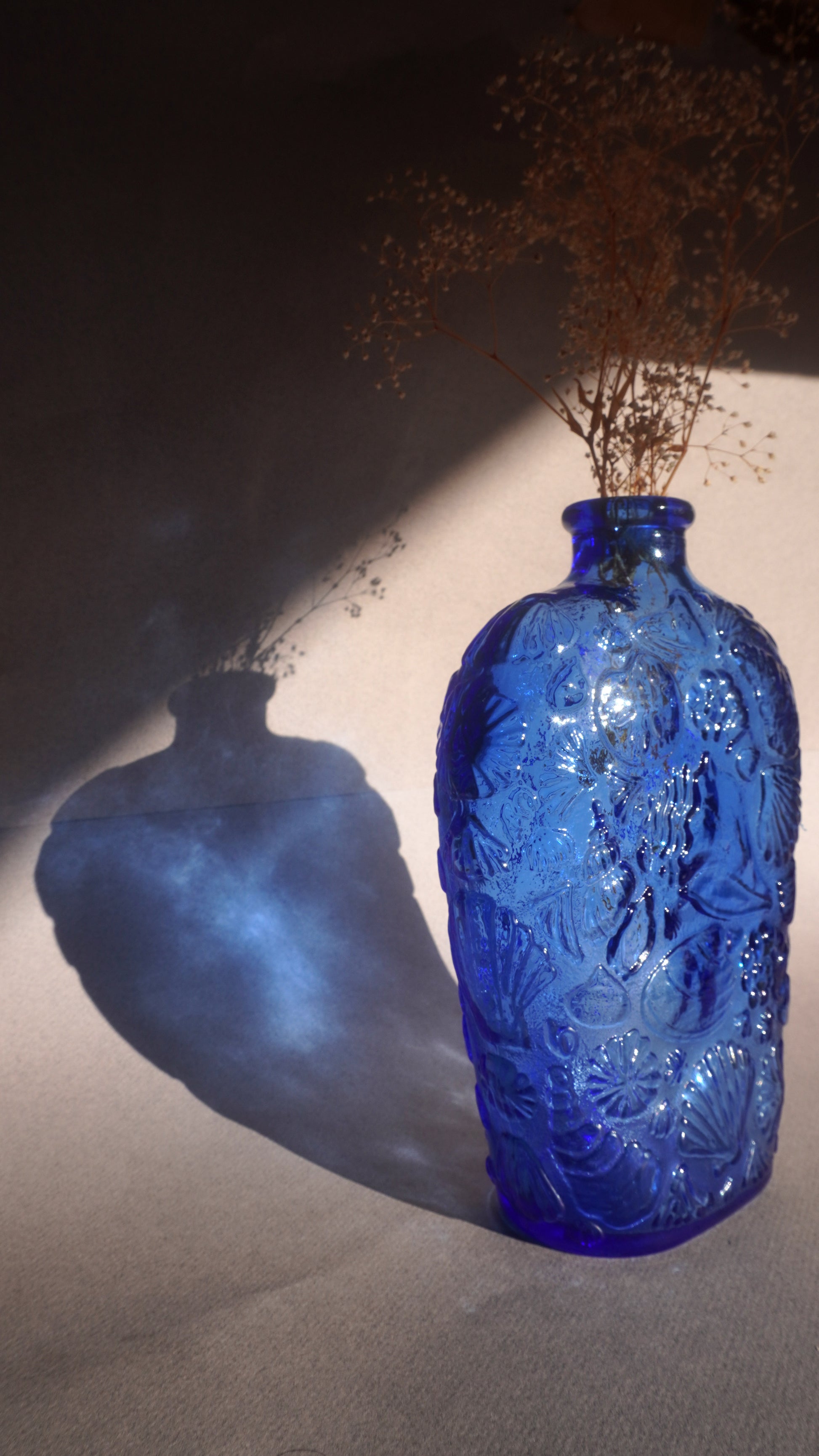 Blue decanter vase with intricate patterns on a dark background