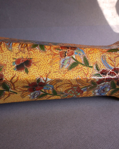 Decorative vase with floral patterns on a yellow background