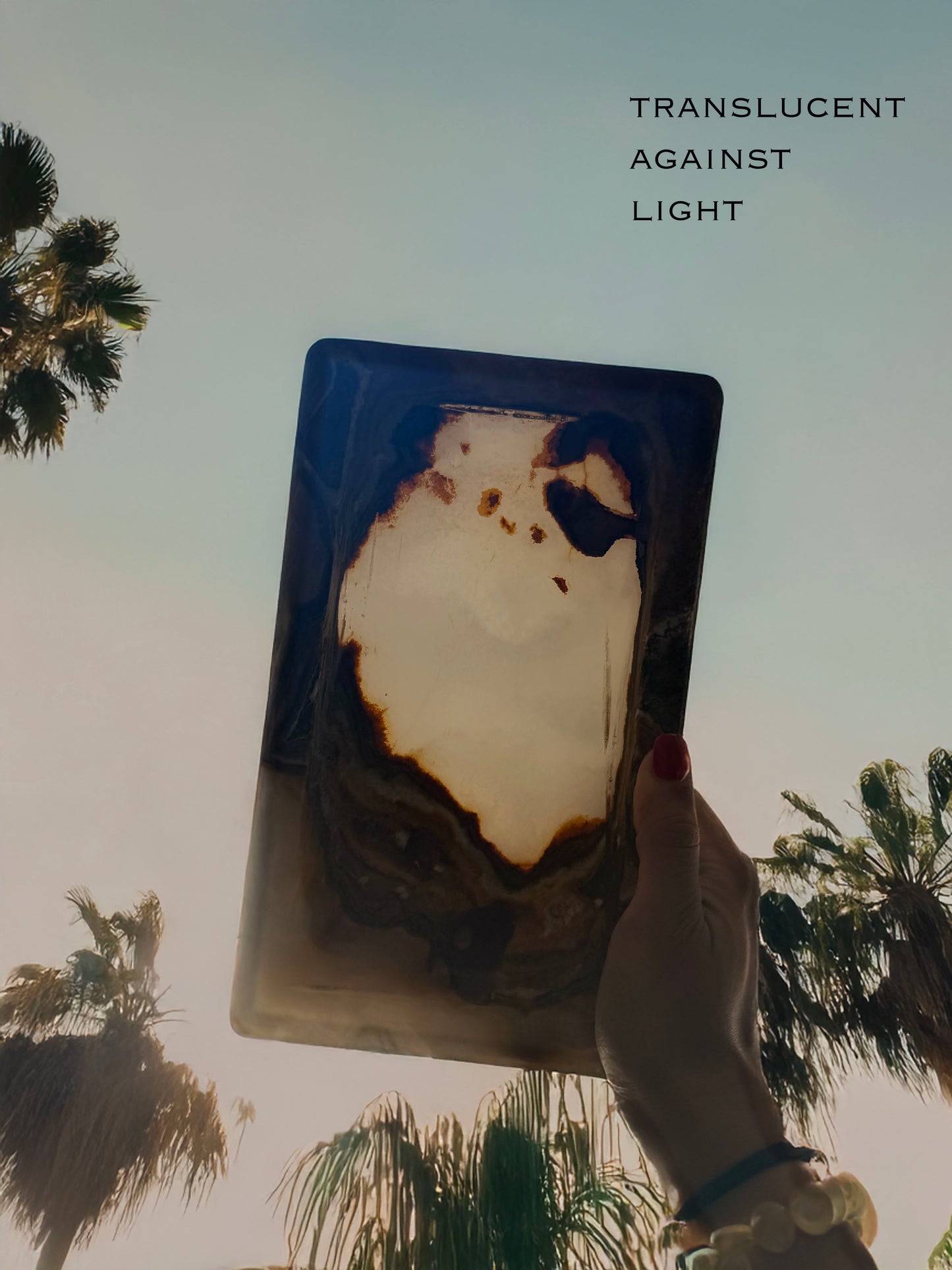 Hand-carved ivory and brown onyx catchall tray with translucent natural stone, raw polish-free onyx vanity tray styled with jewelry and perfume
