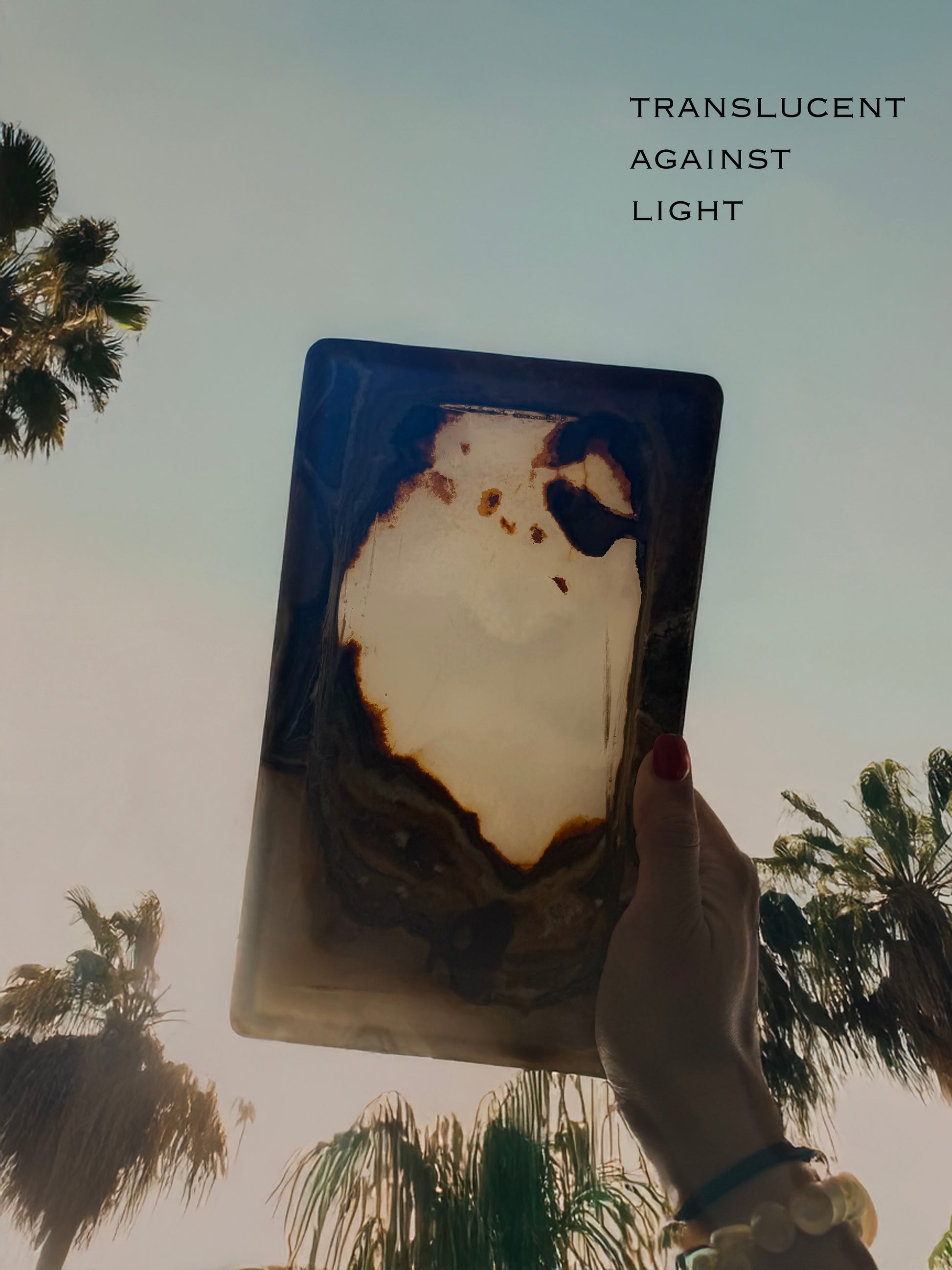 Hand-carved ivory and brown onyx catchall tray with translucent natural stone, raw polish-free onyx vanity tray styled with jewelry and perfume
