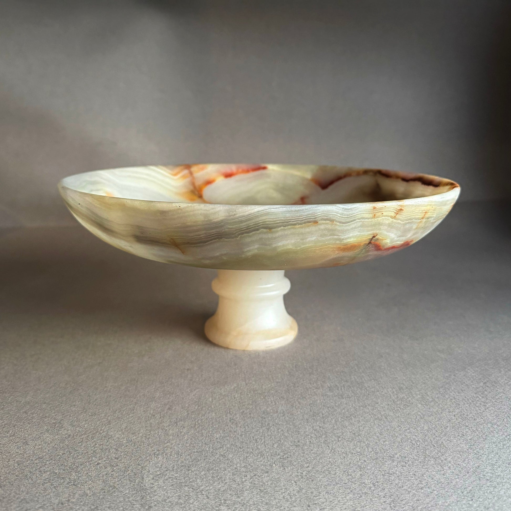 Marble-patterned pedestal bowl on a gray background